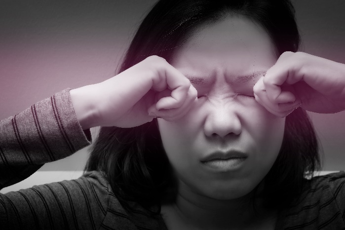 写真:目をこする女性