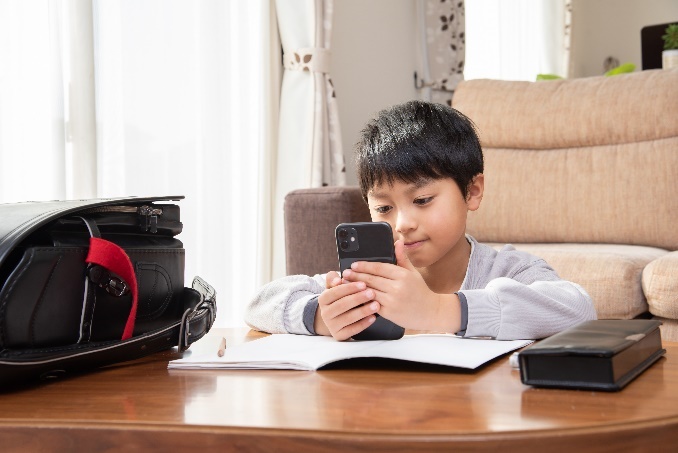 写真：スマホを見る子供